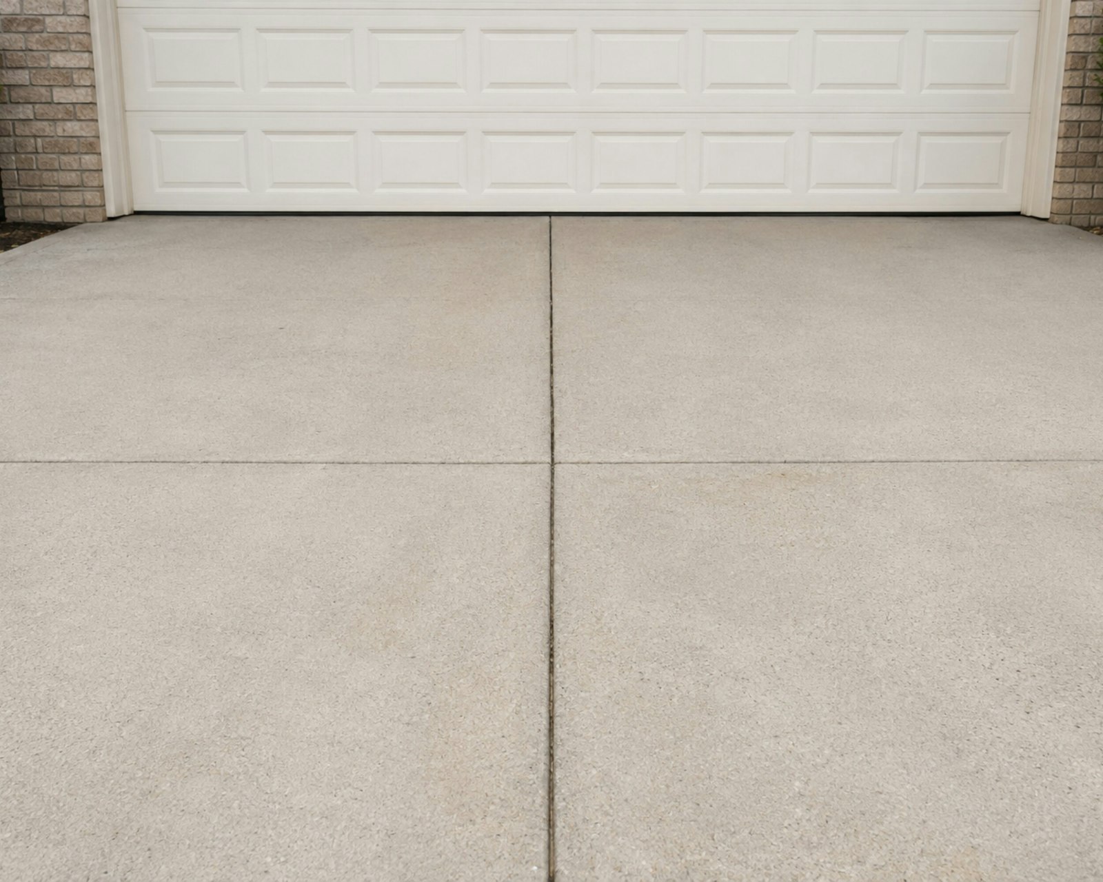 Concrete driveway slab in front of a white garage