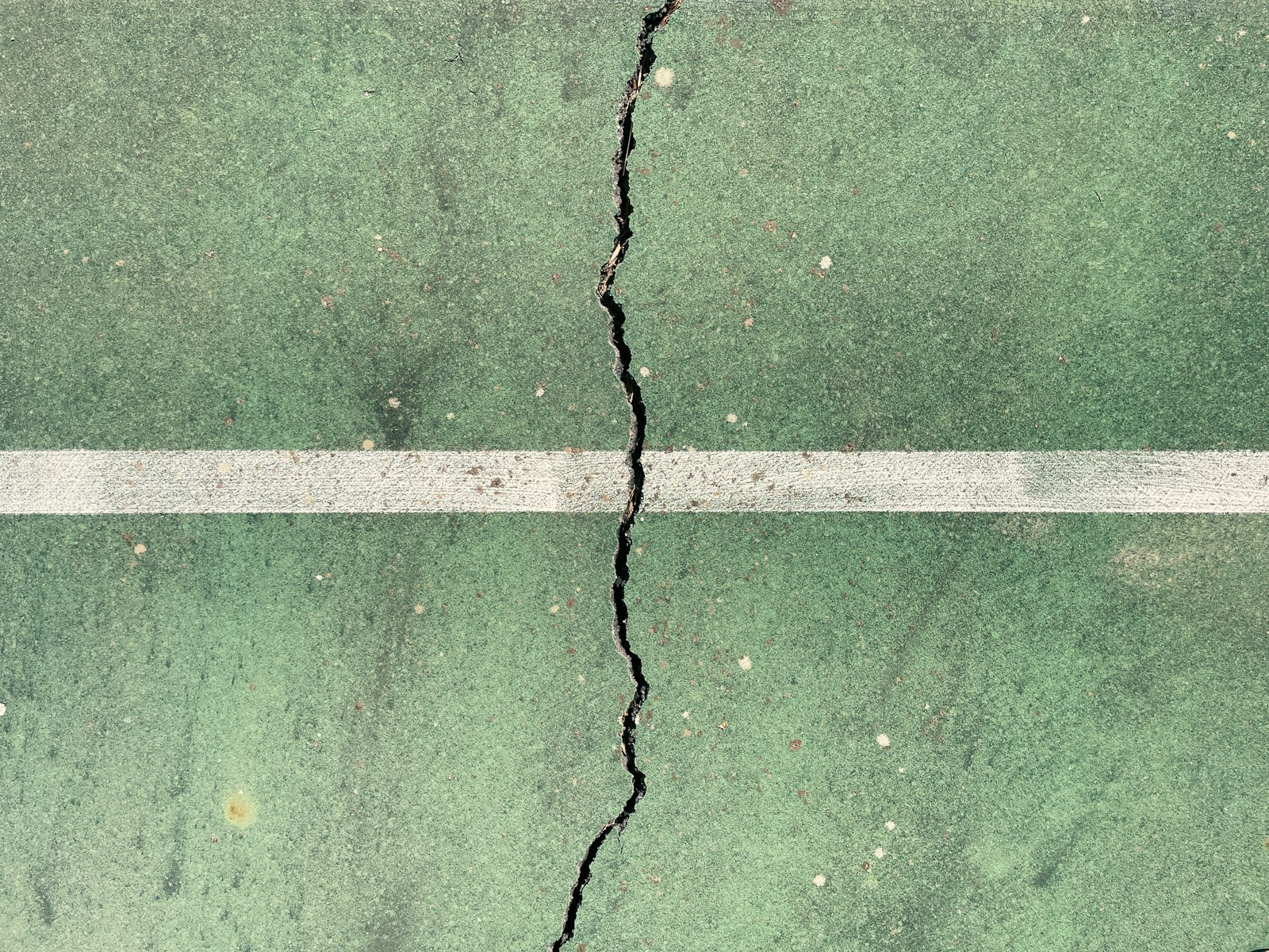 Crack running across a painted concrete slab