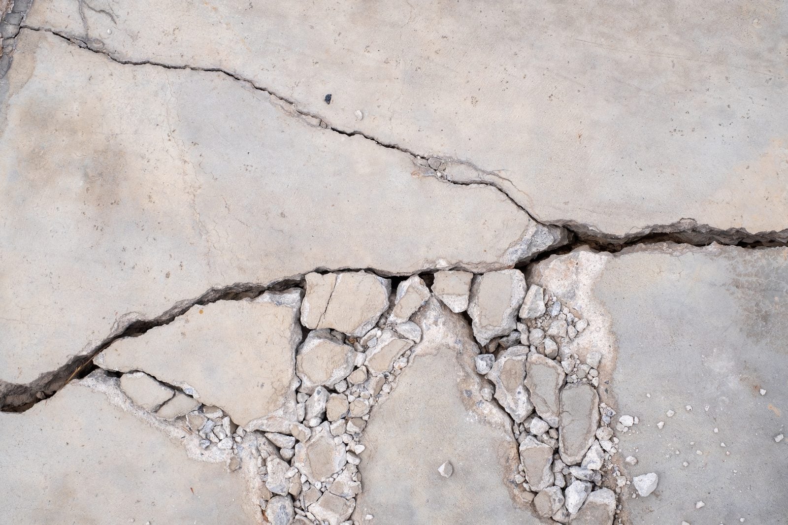Broken, crumbling concrete with wide cracks from ground movement